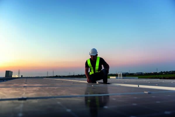 Technician Checking Photovoltaic Cells Panels On Factory Roof Maintenance